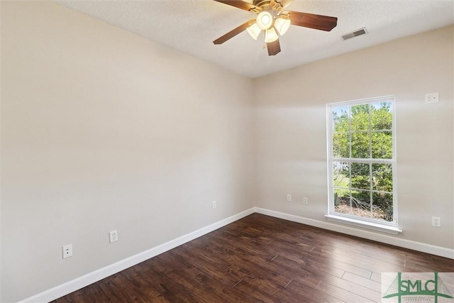 unfurnished room with dark wood-style flooring, visible vents, baseboards, and ceiling fan