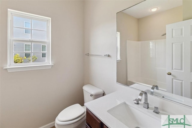 bathroom featuring vanity, toilet, and a shower