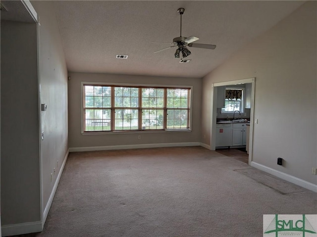 unfurnished living room featuring a sink, lofted ceiling, carpet flooring, a ceiling fan, and baseboards