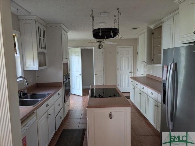 kitchen with a sink, oven, stainless steel refrigerator with ice dispenser, a center island, and white dishwasher