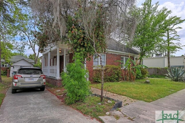 1020 Maupas Ave, Savannah, GA 31401 - view of front of house featuring a front yard, brick siding, and aphalt driveway