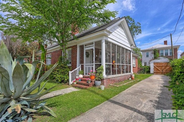 1020 Maupas Ave, Savannah, GA 31401 - bungalow-style house with a sunroom, brick siding, and a front lawn