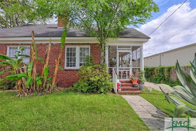 1020 Maupas Ave, Savannah, GA 31401 - view of front of house featuring a chimney, a front yard, brick siding, and fence