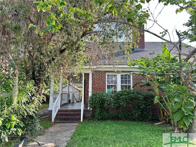1020 Maupas Ave, Savannah, GA 31401 - view of front facade featuring brick siding, a front yard, and a chimney