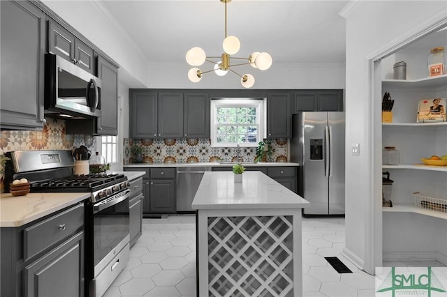 kitchen with appliances with stainless steel finishes, gray cabinetry, a chandelier, tasteful backsplash, and light tile patterned flooring