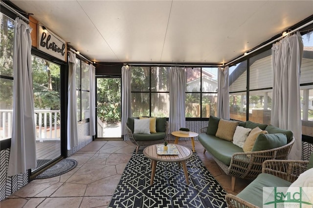 sunroom / solarium featuring healthy amount of natural light and outdoor lounge area