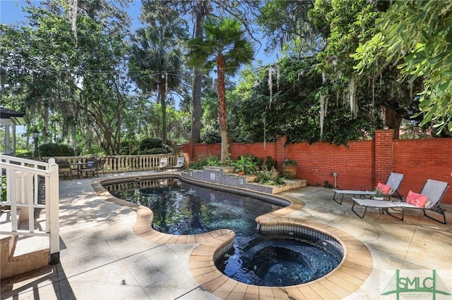 view of pool with a fenced backyard, a patio area, and an in-ground hot tub