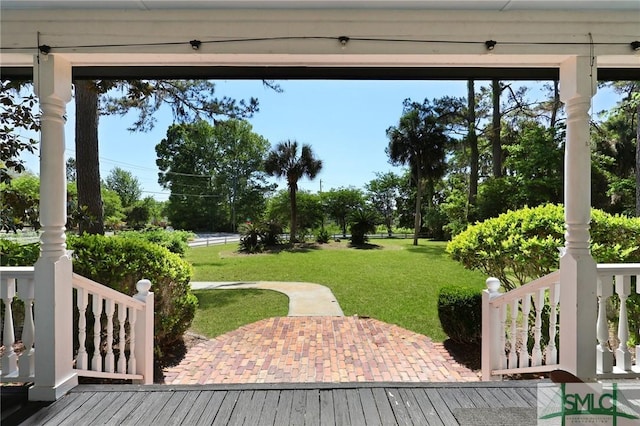 wooden terrace with a lawn and a patio