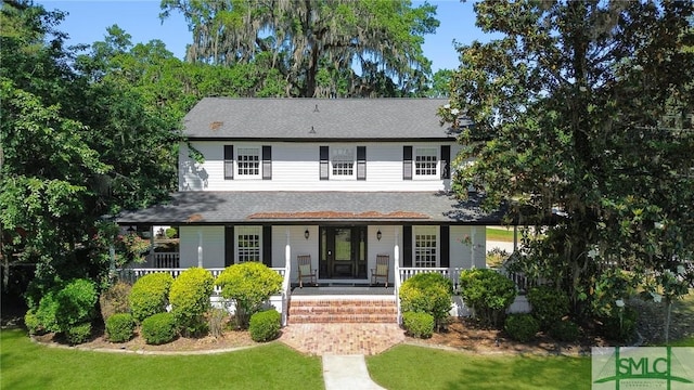 view of front of home with a porch and a front yard