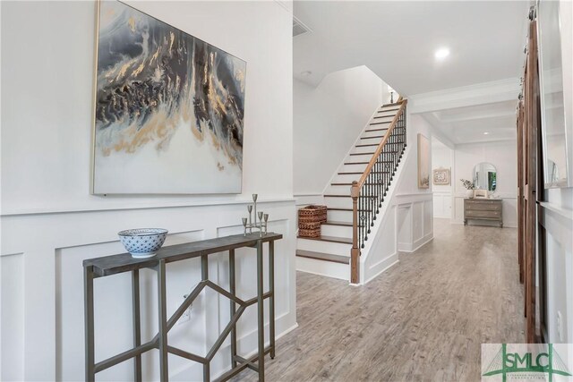 195 Wildlife View Ct N, Richmond Hill, GA 31324 - hall with stairway, wood finished floors, beam ceiling, and a decorative wall