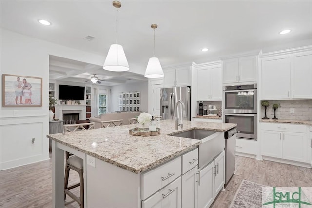 195 Wildlife View Ct N, Richmond Hill, GA 31324 - kitchen featuring stainless steel appliances, ceiling fan, light wood finished floors, an island with sink, and open floor plan