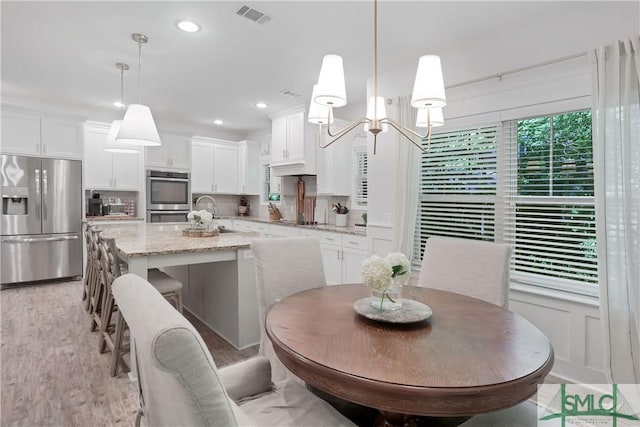 195 Wildlife View Ct N, Richmond Hill, GA 31324 - dining space with light wood-style flooring, recessed lighting, and a chandelier