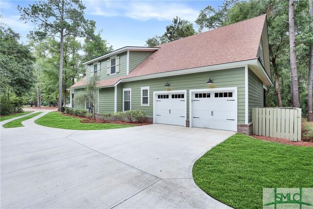 195 Wildlife View Ct N, Richmond Hill, GA 31324 - view of property exterior featuring concrete driveway, roof with shingles, a lawn, and an attached garage