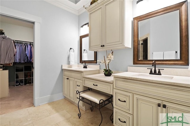 full bathroom featuring double vanity, crown molding, a walk in closet, baseboards, and tile patterned flooring