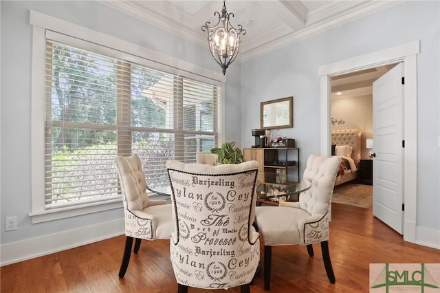 dining space featuring ornamental molding, a chandelier, plenty of natural light, wood finished floors, and beamed ceiling