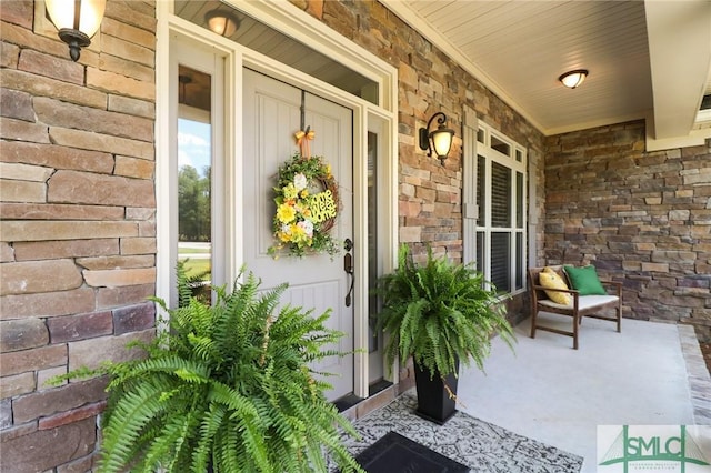 entrance to property featuring covered porch and stone siding