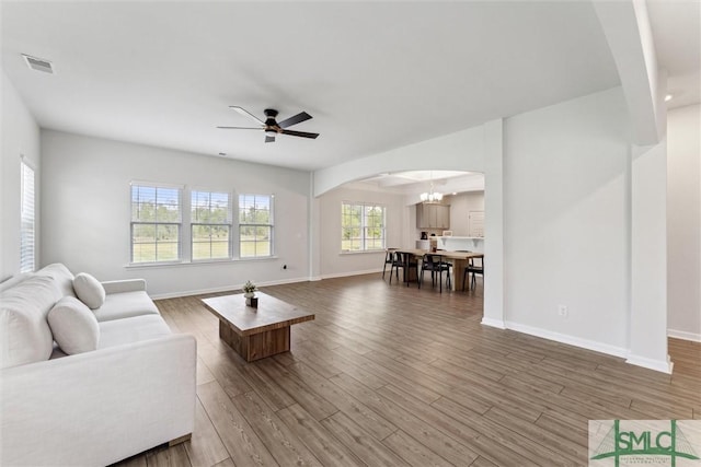 89 Evan Wade Ct NE, Ludowici, GA 31316 - living room featuring arched walkways, a ceiling fan, wood finished floors, baseboards, and a chandelier