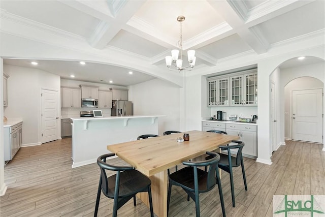 89 Evan Wade Ct NE, Ludowici, GA 31316 - dining area featuring a chandelier, arched walkways, beamed ceiling, coffered ceiling, and light wood-style flooring