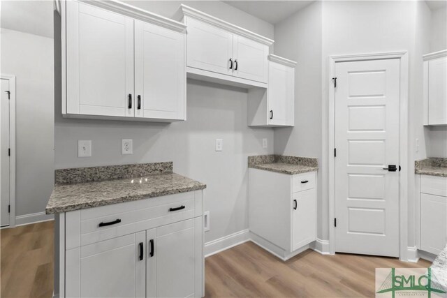 333 Crosswinds Dr, Rincon, GA 31326 - kitchen with light wood-type flooring, white cabinetry, and light stone counters