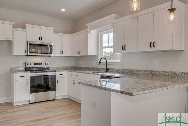 288 Timberlake Dr, Guyton, GA 31312 - kitchen with stainless steel appliances, a peninsula, white cabinets, and recessed lighting