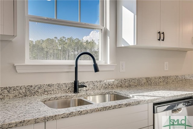 288 Timberlake Dr, Guyton, GA 31312 - kitchen view of stainless steel dishwasher, a sink, white cabinets, and light stone countertops
