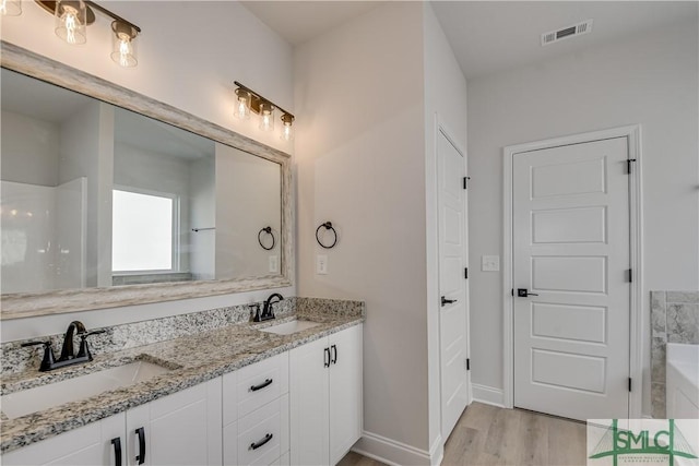 288 Timberlake Dr, Guyton, GA 31312 - bathroom with wood finished floors, double vanity, baseboards, and a tub to relax in