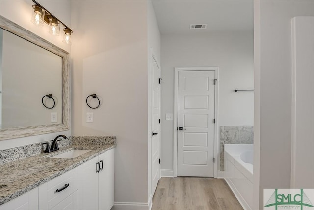 288 Timberlake Dr, Guyton, GA 31312 - bathroom with wood finished floors, vanity, a bath, and baseboards