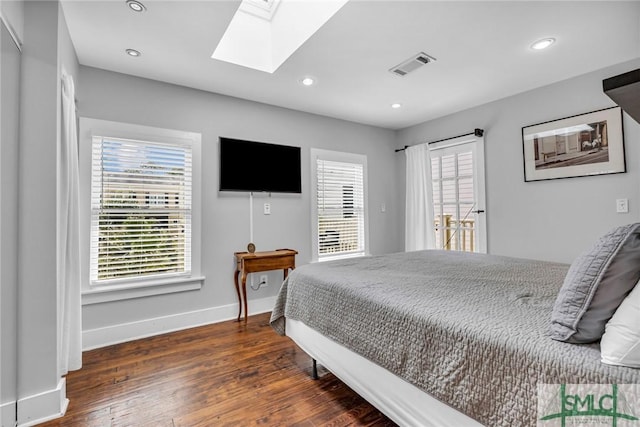 bedroom featuring a skylight, baseboards, wood finished floors, recessed lighting, and access to outside