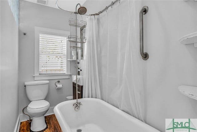 bathroom with toilet, a soaking tub, wood finished floors, baseboards, and a shower with shower curtain