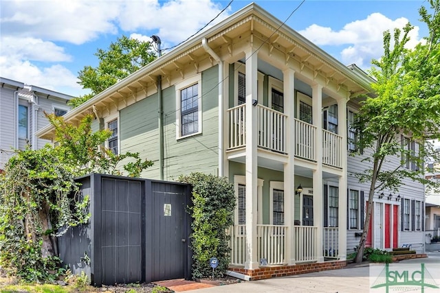 view of side of property featuring a balcony and a porch