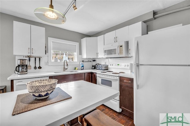 kitchen featuring white appliances, a sink, light countertops, dark wood-style flooring, and white cabinetry