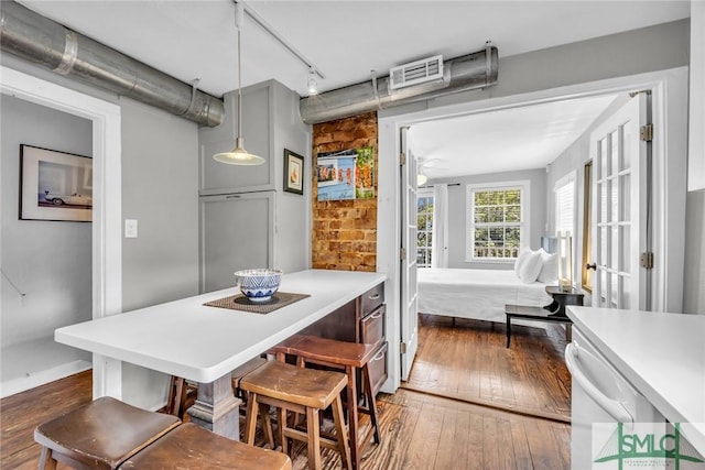 dining space with hardwood / wood-style floors, rail lighting, and baseboards