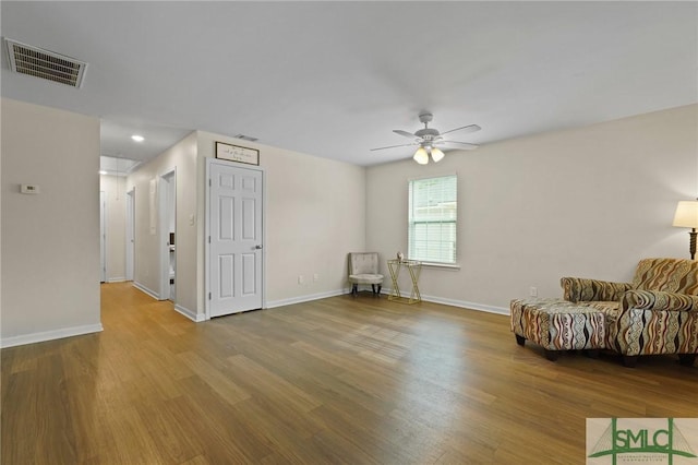 sitting room featuring wood finished floors, ceiling fan, and baseboards