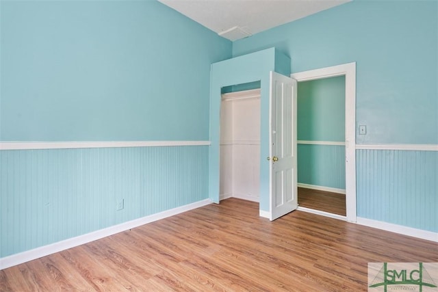 unfurnished bedroom with wood finished floors and baseboards