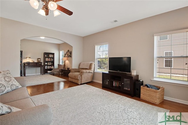 901 Garden Hills Loop, Richmond Hill, GA 31324 - living room featuring arched walkways, wood finished floors, ceiling fan, and baseboards