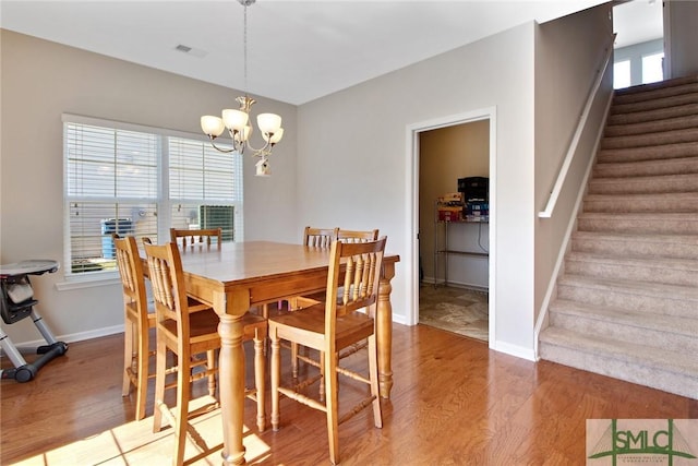 901 Garden Hills Loop, Richmond Hill, GA 31324 - dining space featuring light wood-style floors, stairway, healthy amount of natural light, and a chandelier