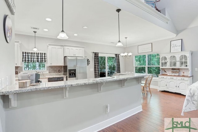 190 Blackjack Oak Dr E, Richmond Hill, GA 31324 - kitchen featuring stainless steel fridge with ice dispenser, white cabinetry, a breakfast bar, ornamental molding, and recessed lighting