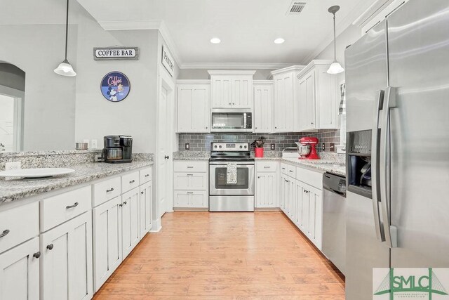 190 Blackjack Oak Dr E, Richmond Hill, GA 31324 - kitchen featuring appliances with stainless steel finishes, crown molding, white cabinets, light wood-style flooring, and backsplash