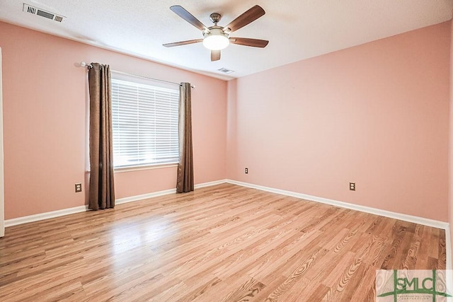 empty room featuring light wood-style flooring, a ceiling fan, and baseboards