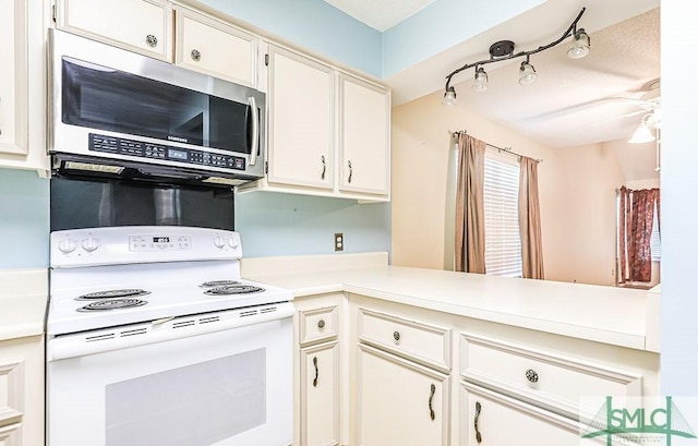 kitchen with white electric range oven, stainless steel microwave, light countertops, and white cabinets