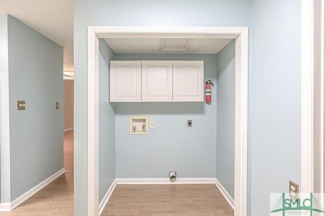 laundry area with washer hookup, cabinet space, electric dryer hookup, and light wood-style flooring