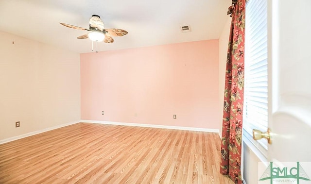 spare room with light wood finished floors, ceiling fan, and baseboards