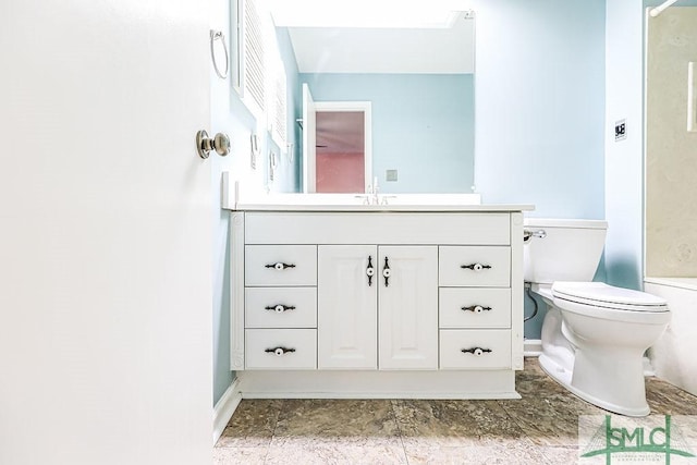 full bathroom featuring baseboards, toilet, vanity, and a shower