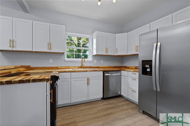 3205 Burroughs St, Savannah, GA 31405 - kitchen with appliances with stainless steel finishes, butcher block counters, a sink, white cabinetry, and light wood finished floors