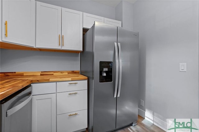 3205 Burroughs St, Savannah, GA 31405 - kitchen featuring stainless steel appliances, butcher block counters, wood finished floors, and white cabinetry