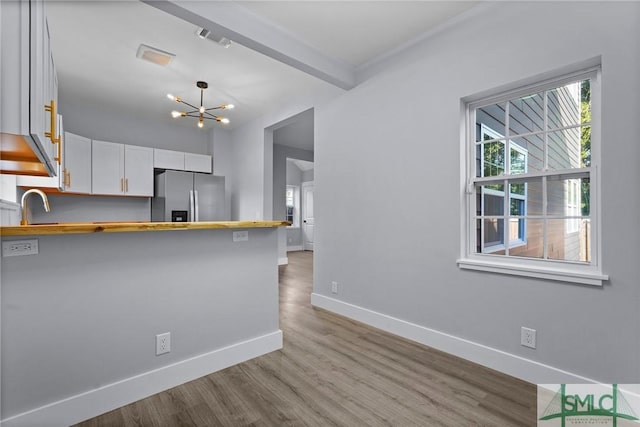 3205 Burroughs St, Savannah, GA 31405 - kitchen with stainless steel fridge with ice dispenser, wooden counters, a chandelier, and a peninsula