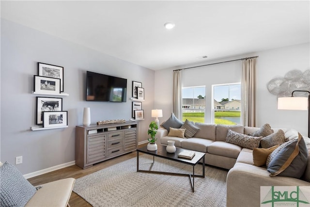 living room with baseboards, wood finished floors, and recessed lighting