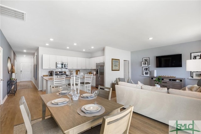 dining area with light wood finished floors, recessed lighting, and baseboards