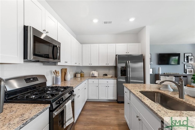 kitchen featuring stainless steel appliances, a sink, white cabinetry, and recessed lighting