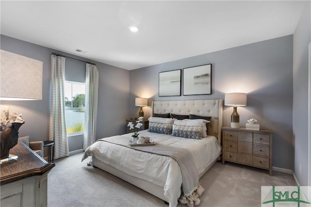 bedroom with light colored carpet and baseboards